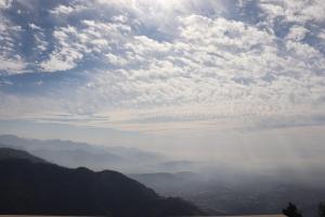 een bewolkte hemel met uitzicht op een stad bij Deodar Cottage - 3BHK Villa by DeodarStays in Mussoorie