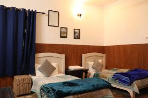 een kamer met 2 bedden en een blauw gordijn bij Deodar Cottage - 3BHK Villa by DeodarStays in Mussoorie