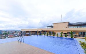 ein Schwimmbad auf dem Dach eines Gebäudes in der Unterkunft Best Place and Cozy Studio at Altuz Seturan Yogyakarta Apartment By Travelio in Seturan