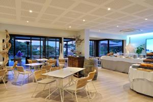 a restaurant with tables and chairs and a counter at Hotel Bartaccia in Propriano