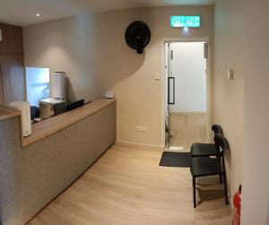 a waiting room with a chair and a sign on the wall at Keteri Boutique Hotel in Kangar