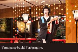 a woman in a kimono standing in front of a store at Yamanaka Onsen Kissho Yamanaka in Kaga