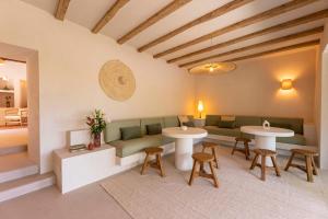 a room with two tables and a couch and chairs at Boutique Hotel Jardines de Palerm in San Jose