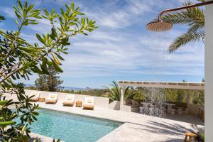 a swimming pool with chairs and a water fountain at Boutique Hotel Jardines de Palerm in San Jose