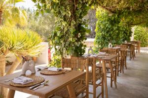 a row of wooden tables and chairs with plants at Boutique Hotel Jardines de Palerm in San Jose