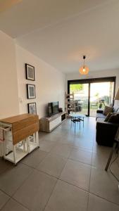 ein Wohnzimmer mit Sofa und Tisch in der Unterkunft Appartement T2 - Rez-de-Jardin, proche plage et commerces in Calvi