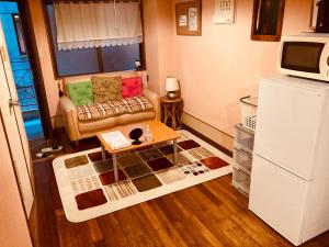 a living room with a couch and a coffee table at Hostel Hakuseiso in Naha