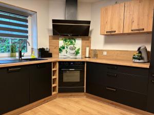 a kitchen with black cabinets and a black oven at FeWo Wiehl-Marienhagen, Modern, ruhig, ländlich in Wiehl
