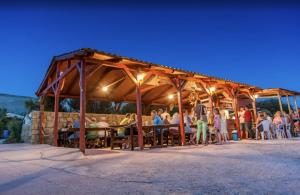 a group of people sitting in a wooden pavilion at Tonino Apartment in Pag