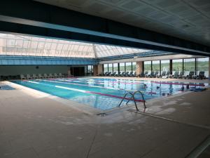 ein großes Schwimmbecken mit Liegestühlen in einem Gebäude in der Unterkunft RaAy in Brăila
