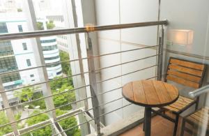 a table and chair on a balcony with a window at Hotel Skypark Central Seoul Pangyo in Seongnam
