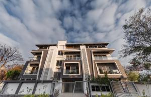 a tall white building with a sky in the background at Seven Sands I Forest Pool Villa One I 6 BHK in Lonavala