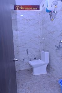 a bathroom with a toilet and a stone wall at Shri Ramnarayan Homestay in Prayagraj