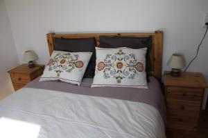 uma cama com duas almofadas e dois candeeiros em mesas de cabeceira em Gite Labradors De Bailly - Giverny em Saint-Pierre-la-Garenne