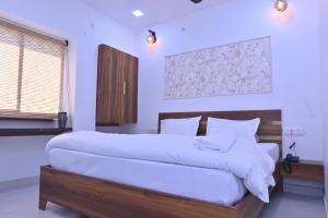 a bedroom with a large bed with white sheets at Shri Ramnarayan Homestay in Prayagraj