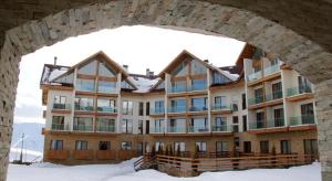 a large building in the snow under an archway at Gudauri Lounge Apartment in Gudauri