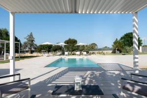 a patio with a swimming pool and a white pergola at CHIALE Holiday Villa in Polignano a Mare