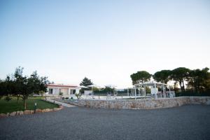 a driveway with a stone wall and a house at CHIALE Holiday Villa in Polignano a Mare