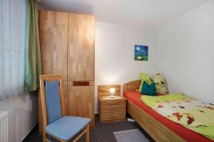 ein kleines Schlafzimmer mit einem Bett und einem Stuhl in der Unterkunft Apartment Todtmoos 3 in Todtmoos
