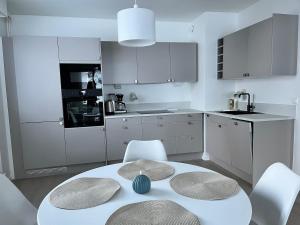 a kitchen with a white table and white chairs at Relaxing&Cozy doubleroom home in Jyväskylä