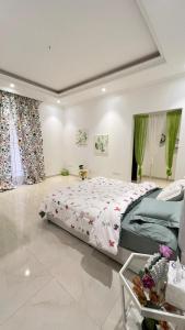 Un dormitorio grande con una cama grande y cortinas verdes. en شقة غرفتين نوم وصالة وحديقة خارجية, en Riad