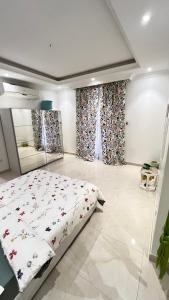 Un dormitorio con una cama y cortinas en una habitación. en شقة غرفتين نوم وصالة وحديقة خارجية, en Riad