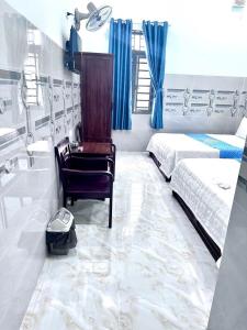 a bedroom with a chair and a bed and a sink at Hotel PHƯƠNG HOA in Phù Cát +6 photos