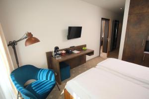 a bedroom with a bed and a chair and a desk at Romantik Hotel Landhaus Biewald in Göttingen