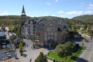 une vue de tête sur un grand bâtiment avec une tour d'horloge dans l'établissement Tour des Voyageurs, à Mont-Tremblant