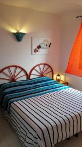 カーラ・リベロットにあるZefiro IUN P2016のベッドルーム1室(青と白のストライプの毛布付きのベッド1台付)