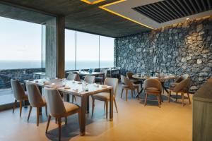 a restaurant with tables and chairs and large windows at BANCAL HOTEL and SPA in San Sebastián de la Gomera