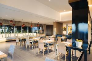 a restaurant with tables and chairs and windows at BANCAL HOTEL and SPA in San Sebastián de la Gomera