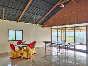 a room with two ping pong tables and chairs at Mizzle Resort in Padinjarathara