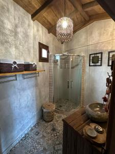 a bathroom with a shower and a sink and a chandelier at Luxury Suites in Villa Anasia, Amaryllis in Skotina +12 photos