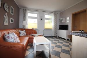 un soggiorno con un divano e un tavolo di Kapitänshaus FW 2 EG re a Wustrow