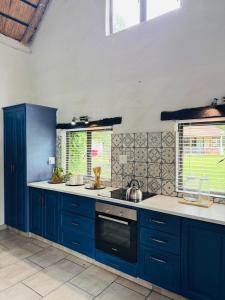 a kitchen with blue cabinets and a stove top oven at Casa De La Luna in Winterton