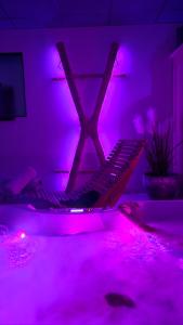 a room with purple lights and a table with a keyboard at Espace évasions Loft Kis LOVE ROOM in Toulouse