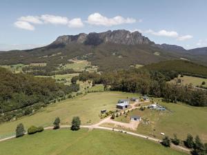 an aerial view of a house in a field with a mountain at Hillside Hideout by Tiny Away in West Kentish