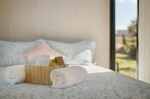 a basket of towels on a bed with a window at Hillside Hideout by Tiny Away in West Kentish