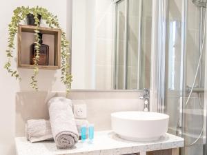a bathroom with a white sink and a mirror at Le Cosy Shelby Proche gare 150m in Villefranche-sur-Saône +21 photos