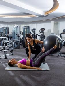 a woman is laying on the floor in a gym at Grand Cosmopolitan Hotel in Dubai