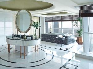 a bathroom with a mirror and a sink and a tub at Dusit Thani Abu Dhabi in Abu Dhabi