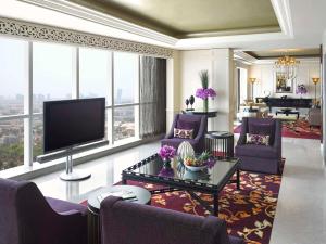 a living room with purple furniture and a flat screen tv at Dusit Thani Abu Dhabi in Abu Dhabi