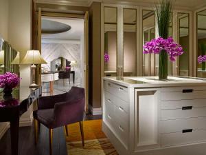 a room with a white dresser with purple flowers in a vase at Dusit Thani Abu Dhabi in Abu Dhabi +37 photos