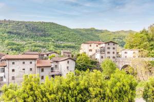 an overview of a town with a bridge and mountains at Il guardiano del Castello in Fivizzano