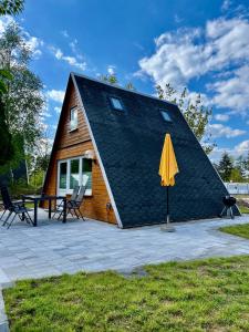ein Haus mit einem gelben Regenschirm davor in der Unterkunft Finnhütten am Storkower See in Brandenburg in Storkow