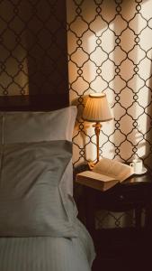 a bed with a lamp and a book on a table at Too-Good Premium Apartments in Krakow +80 photos