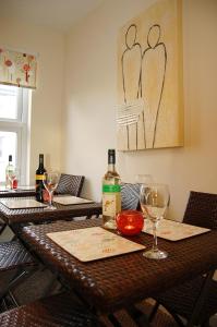 a table with a bottle of wine and wine glasses at Saint Cadfans Lodge in Tywyn