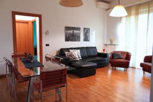 a living room with a black couch and a table at Roma 1 Apartment - THE V Collection in Turate