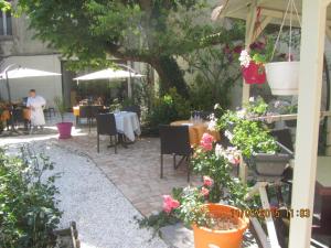 un patio con mesas, sillas y algunas flores en Logis Hôtel Au Croissant, en Buzançais